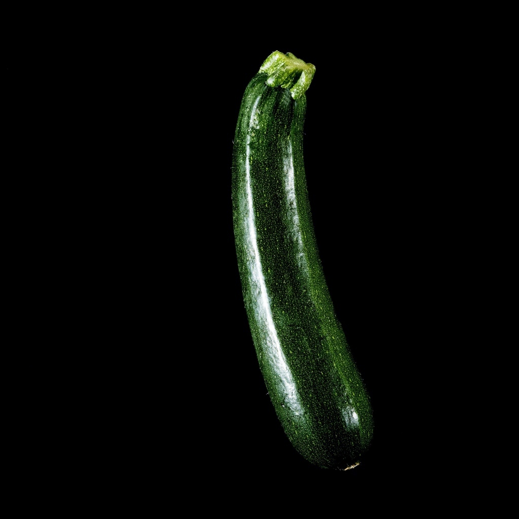 Зеленый кабачок на черном фоне