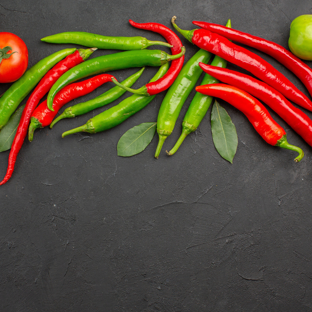 Острый перец чили на столе с помидорами