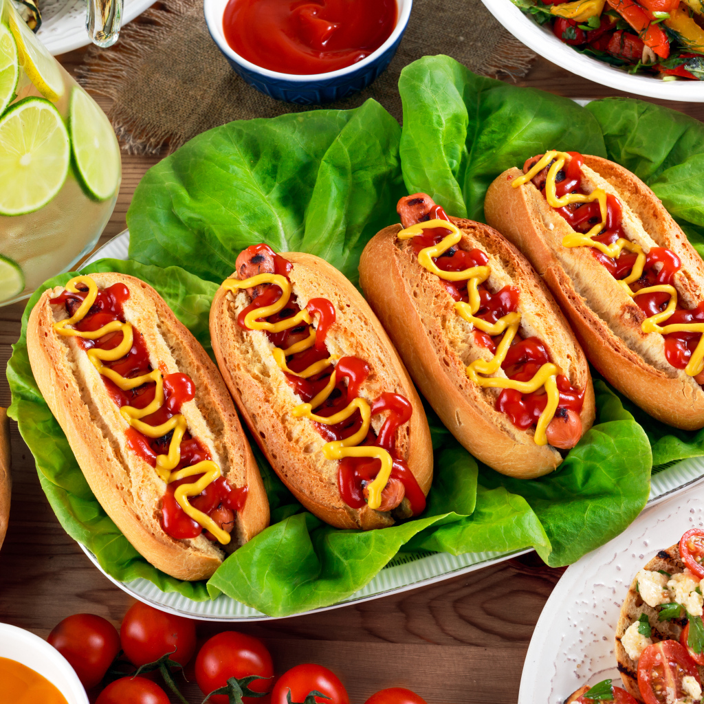 Хот доги на тарелке с листьями салата