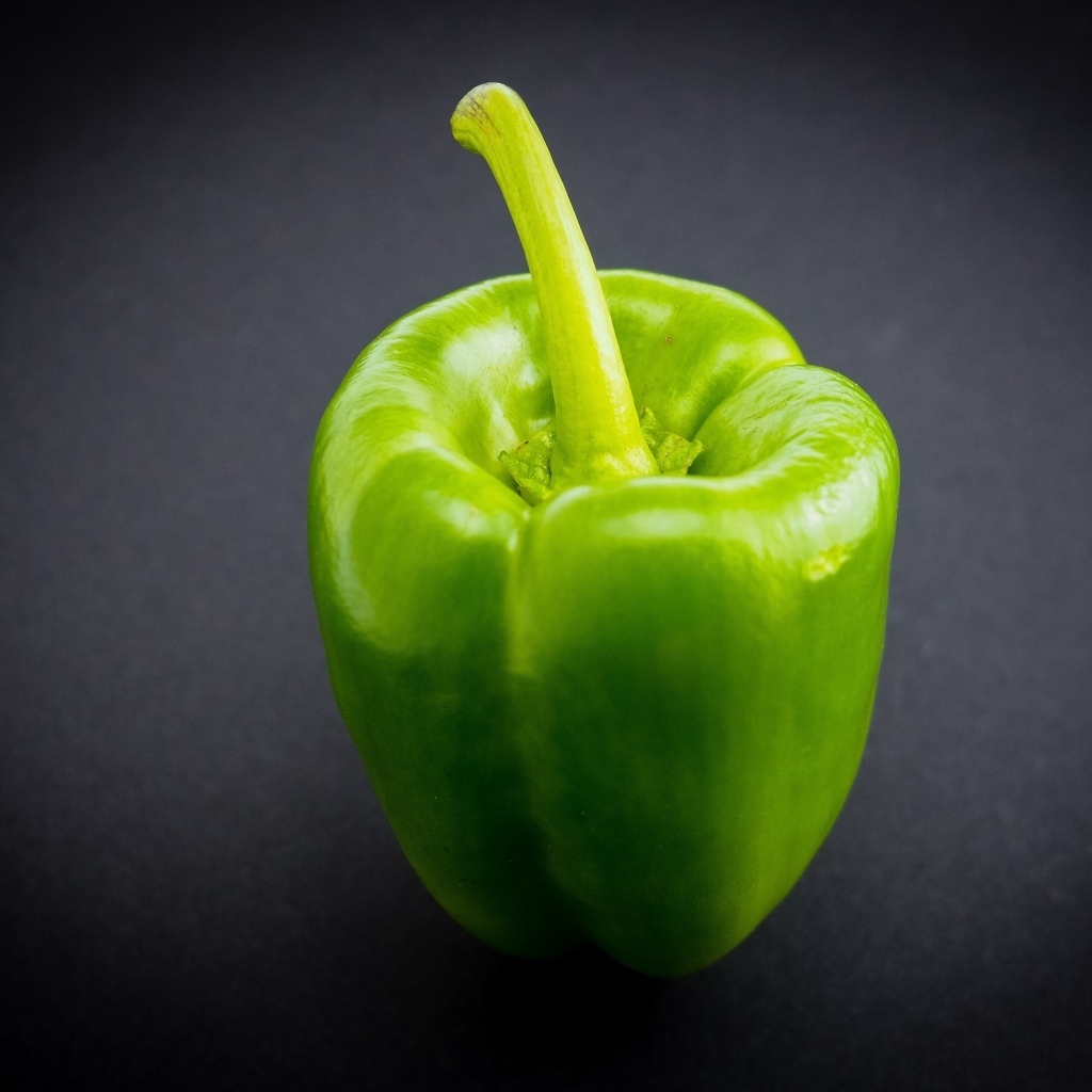 Большой зеленый перец на сером  фоне