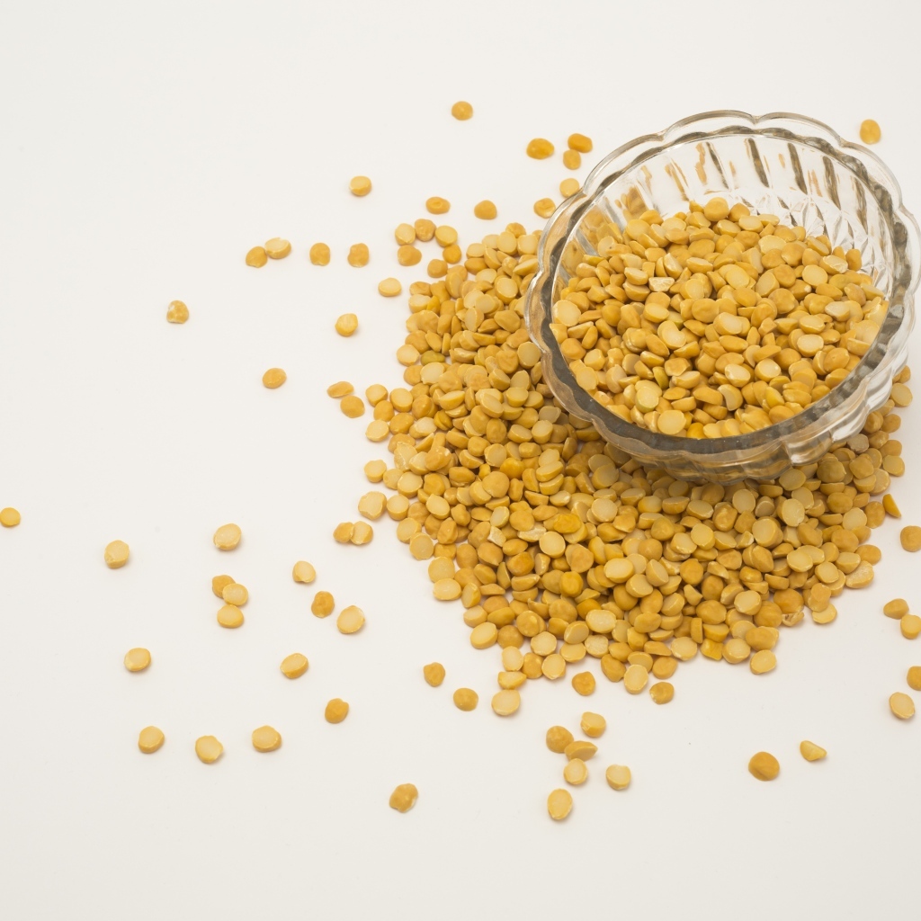 Чечевица рассыпана на белом фоне