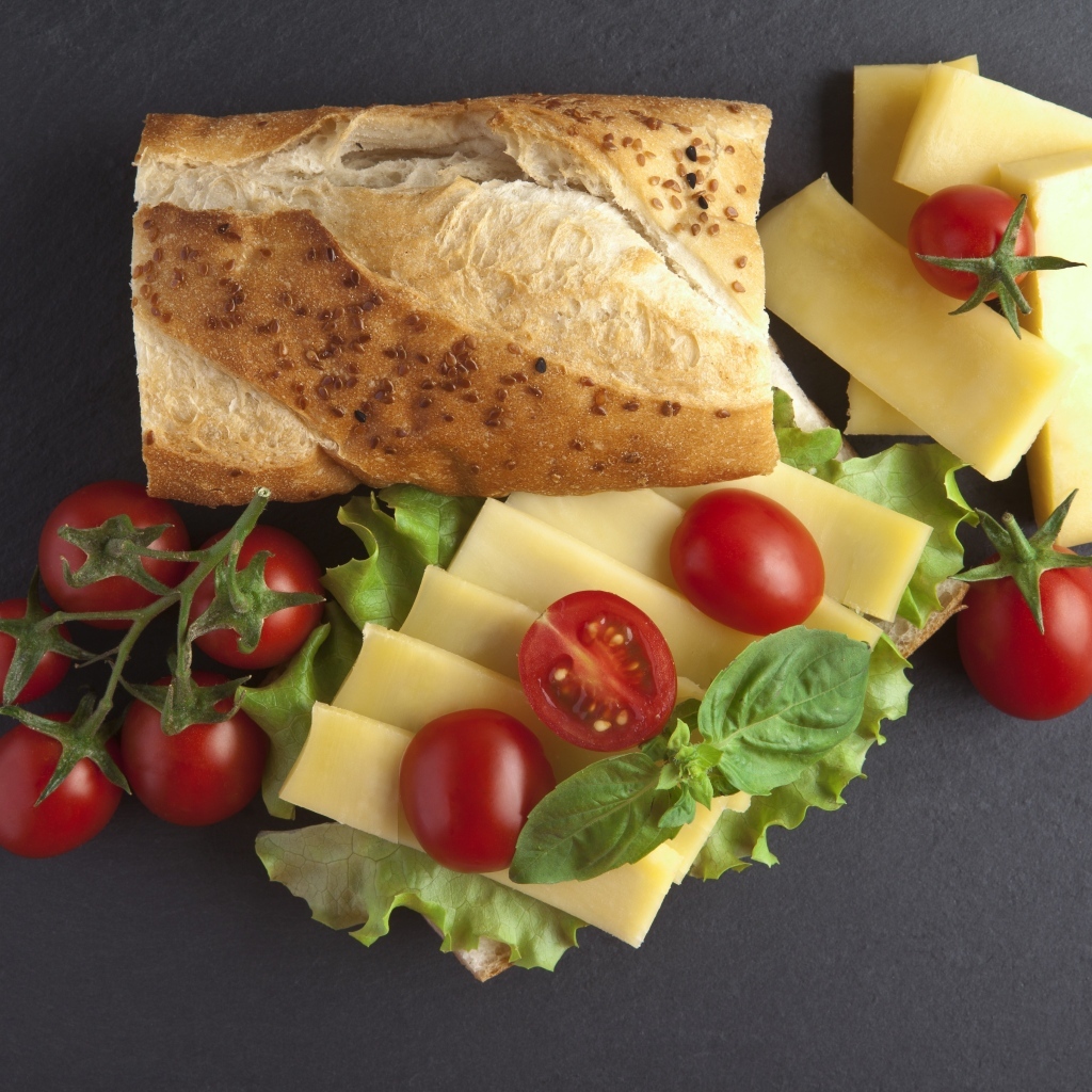 Батон с сыром и помидорами на сером фоне