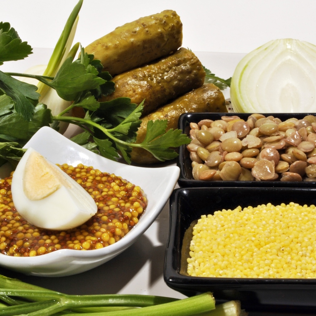 Пшено на столе с огурцами луком и горчицей