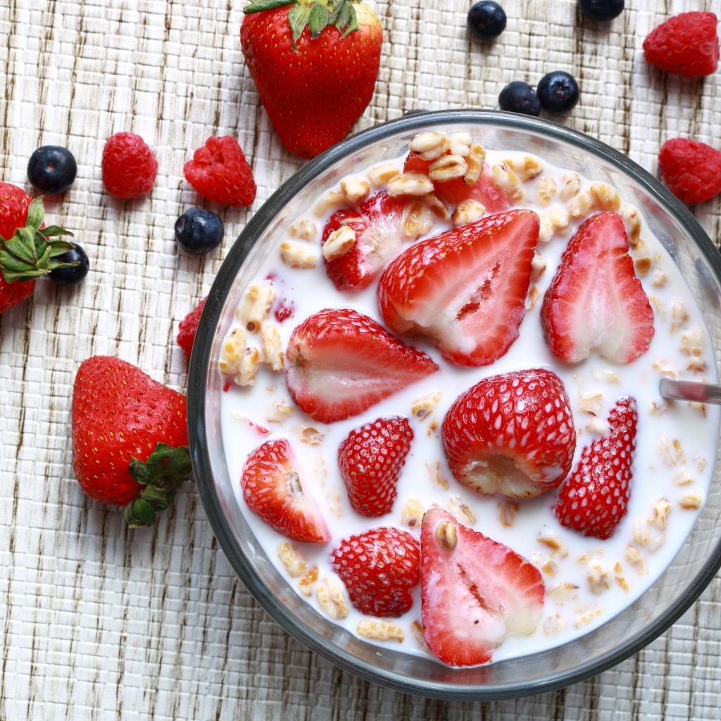 Овсянка с молоком в тарелке с ягодами малины