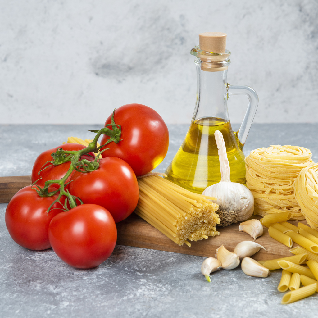 Паста, помидоры и масло на столе