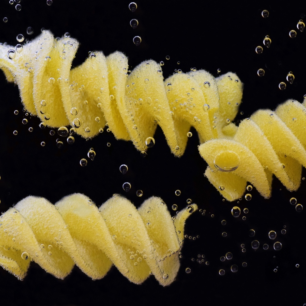 Макароны в воде на черном фоне