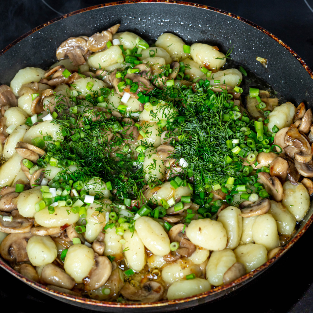 Картофель с шампиньонами и зеленым луков в сковороде