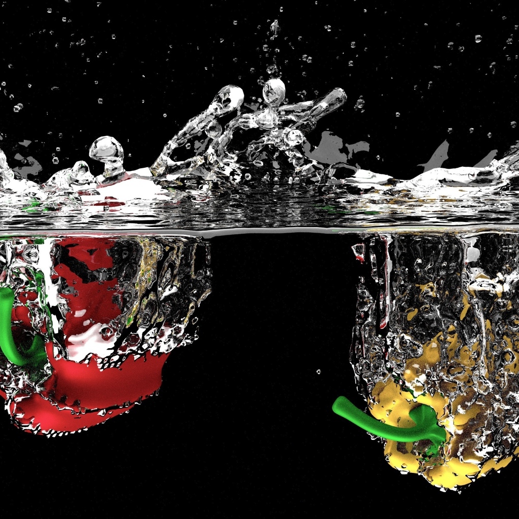 Красный и желтый перец в воде на черном фоне