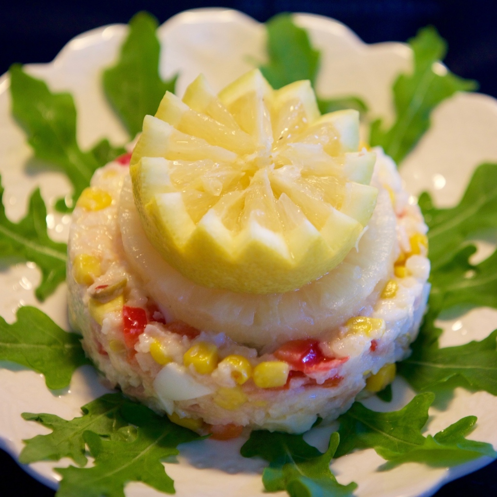 Салат на тарелке с лимоном и рукколой