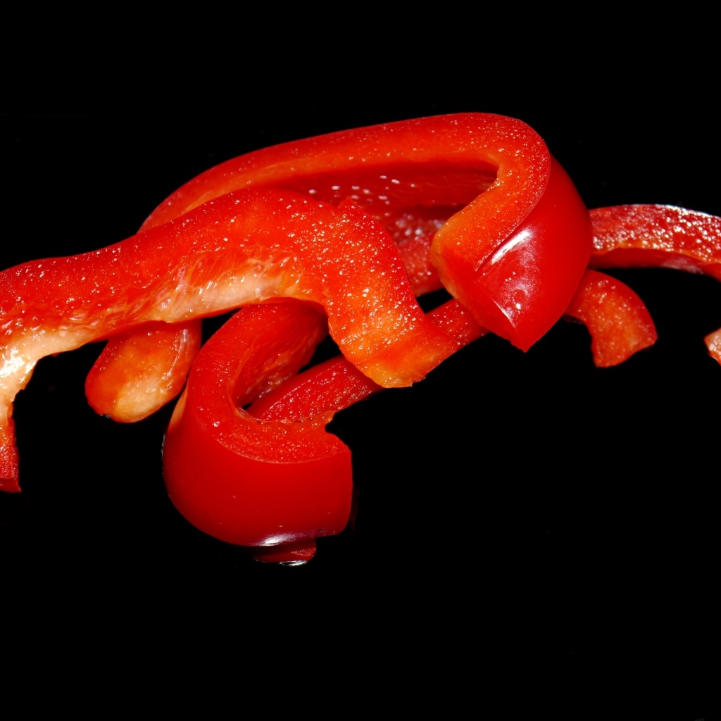 Нарезанный сладкий красный перец на черном фоне