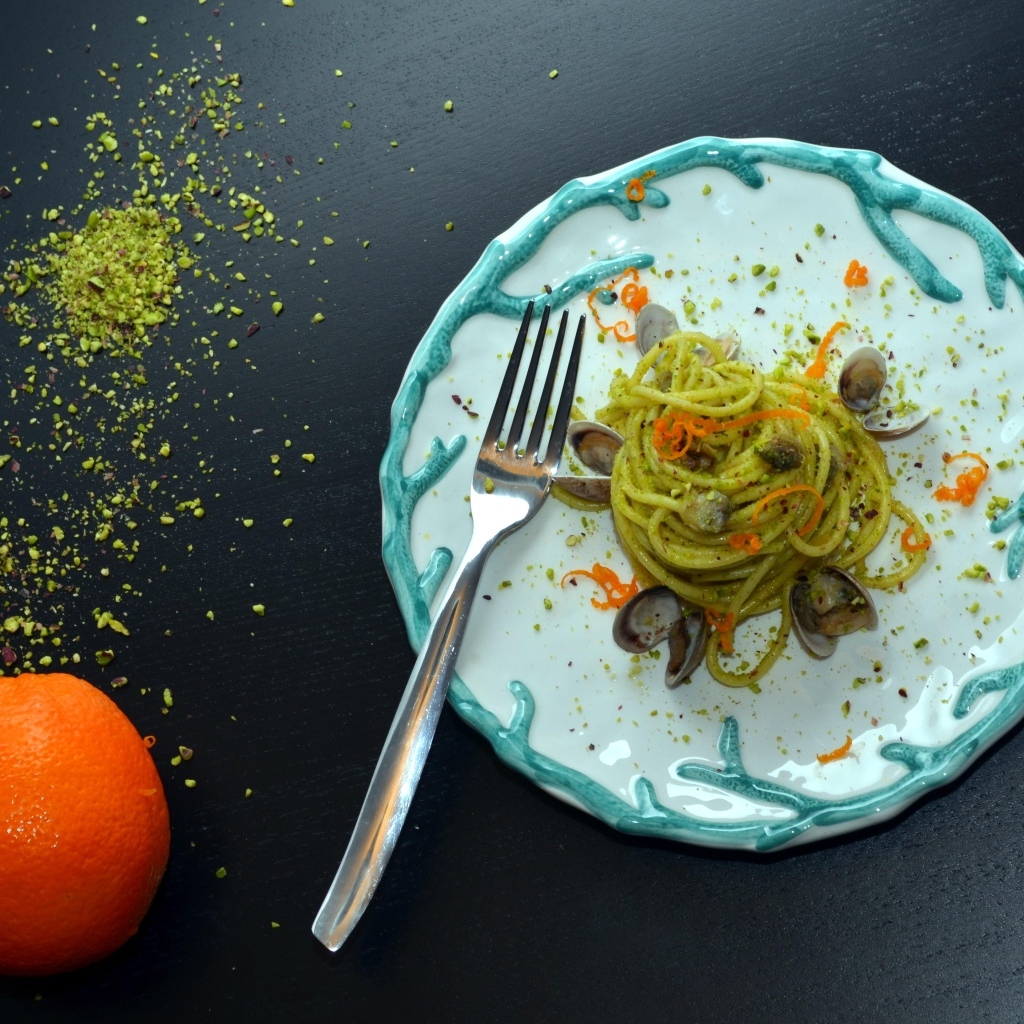 Спагетти с морепродуктами на столе с апельсинами