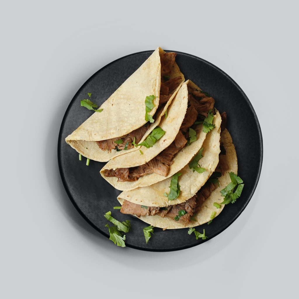 Блюдо тако в тарелке на сером фоне