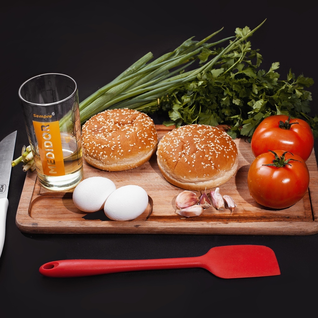 Овощи, яйца, зелень и булочки на черном фоне