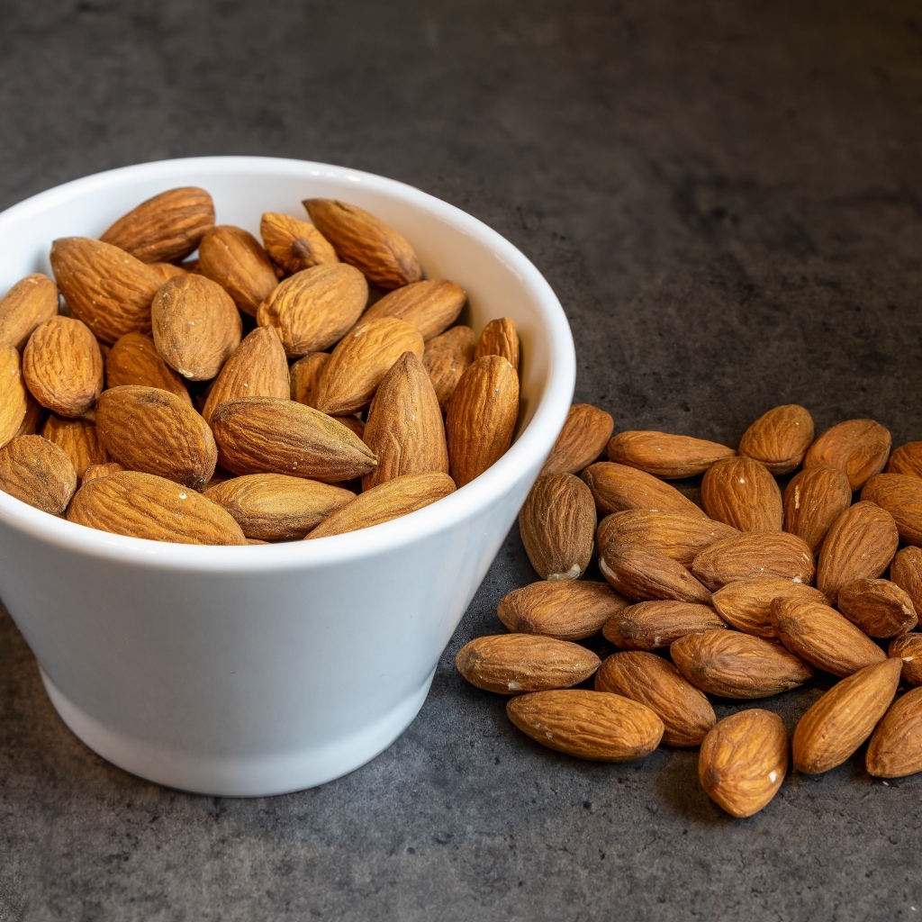 Миндальные орехи в белой пиале на столе