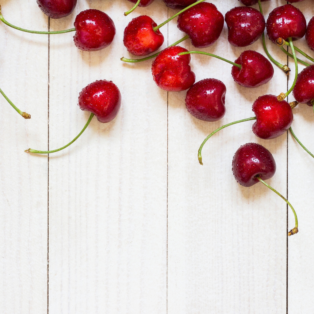 Аппетитные свежие красные ягоды черешни на белом столе