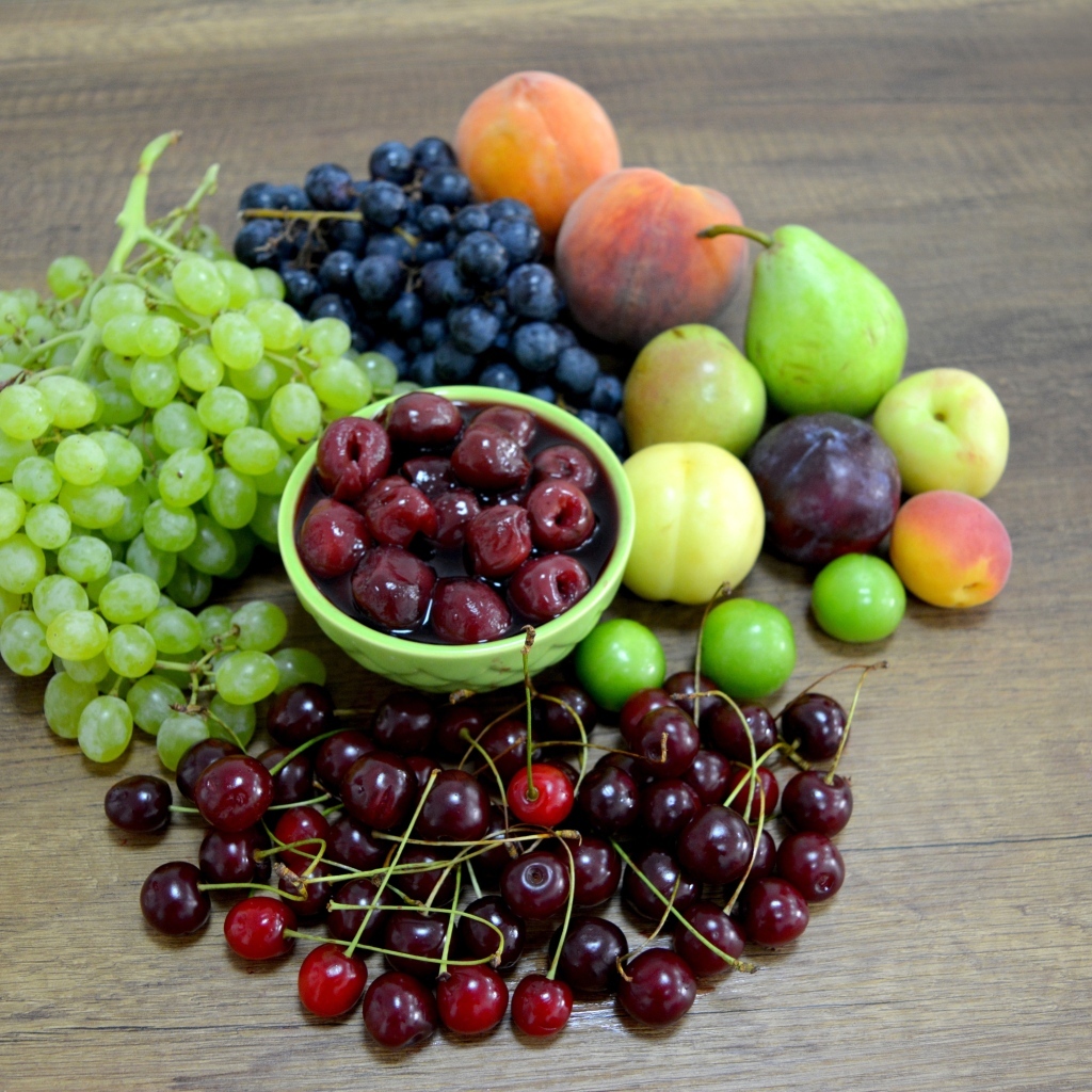 Аппетитные сладкие фрукты и ягоды на деревянном столе