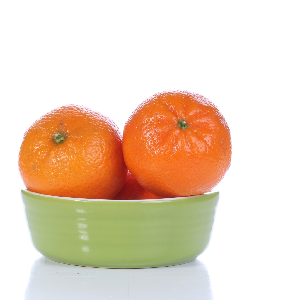 Красивые мандарины в миске на белом фоне
