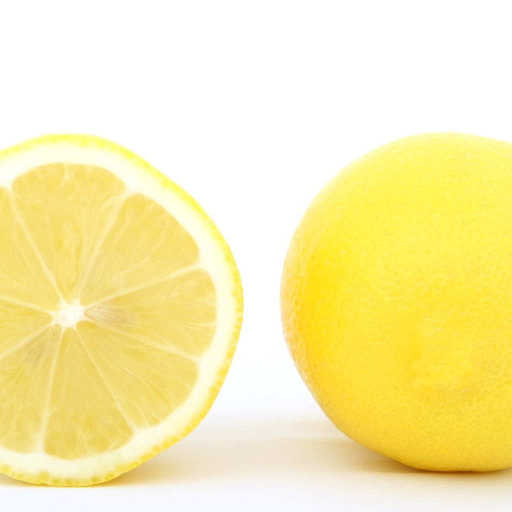 Большой желтый спелый лимон на белом фоне