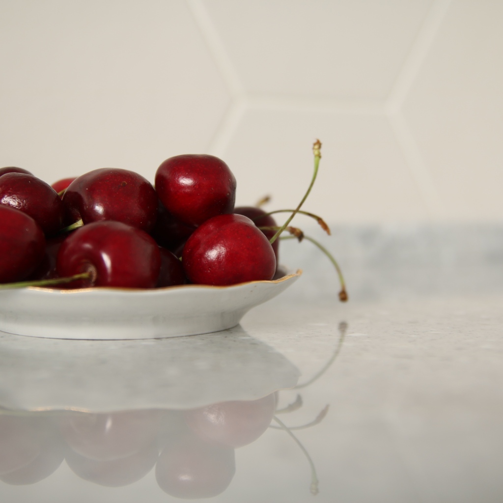 Вкусные сладкие черешни на белой тарелке