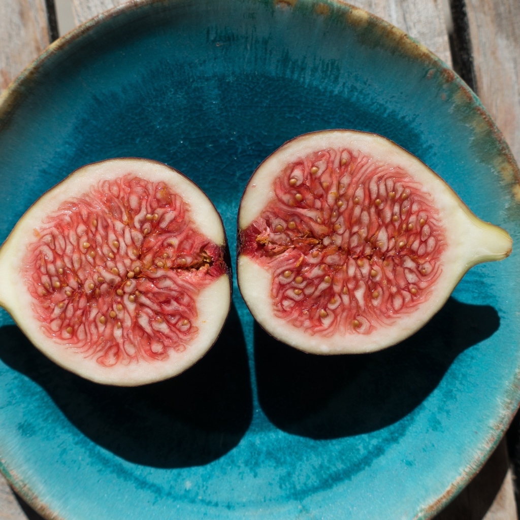 Половинки инжира на голубой тарелке