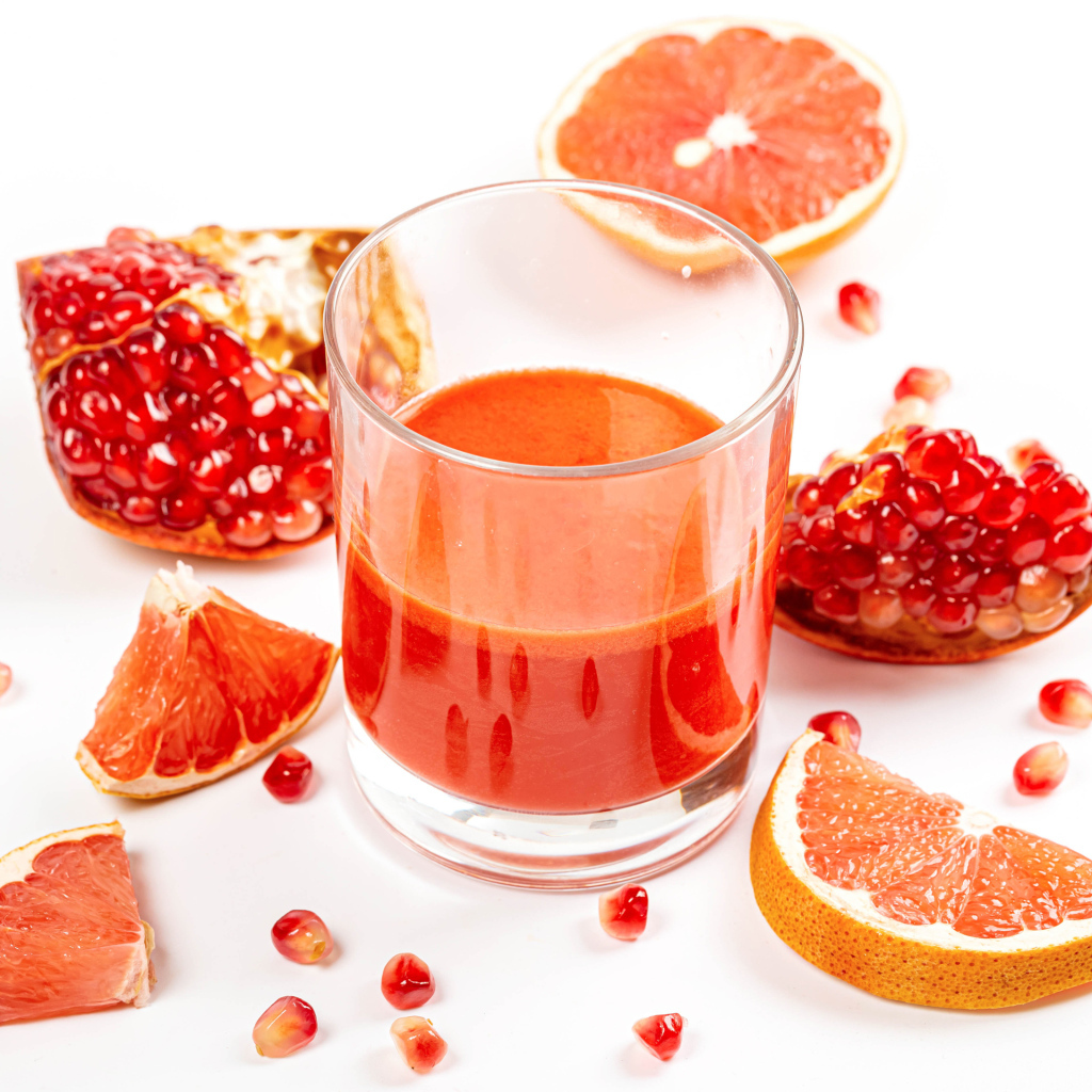 Грейпфрут и гранат на столе с соком