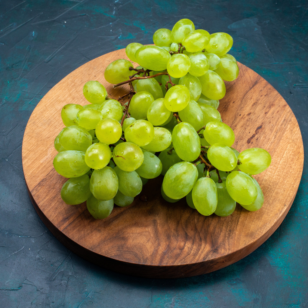 Зеленый виноград на деревянной доске