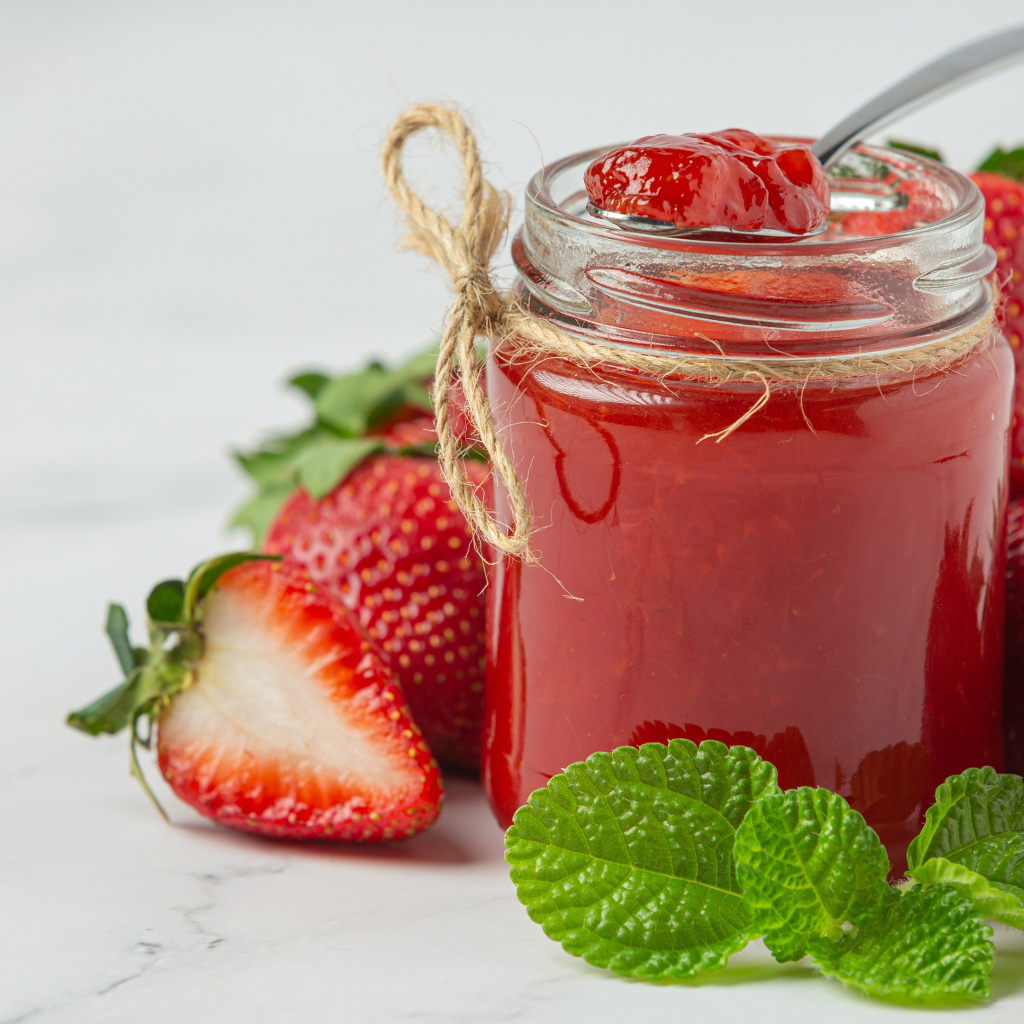 Банка клубничного джема со свежими ягодами
