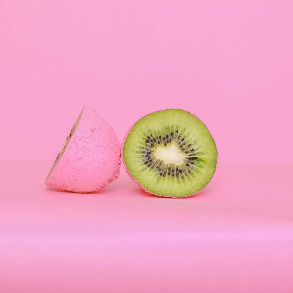Половинки киви на розовом фоне