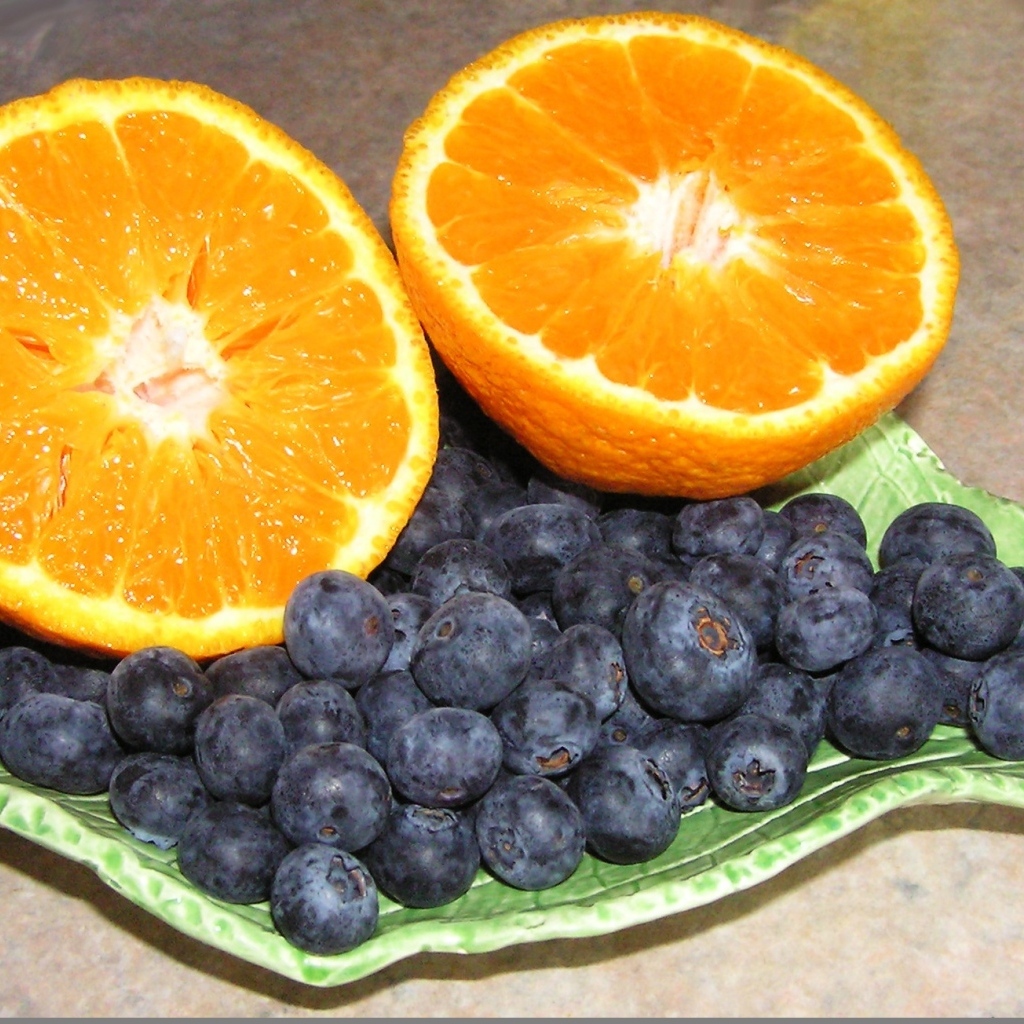 Половинки апельсина с ягодами черники на столе