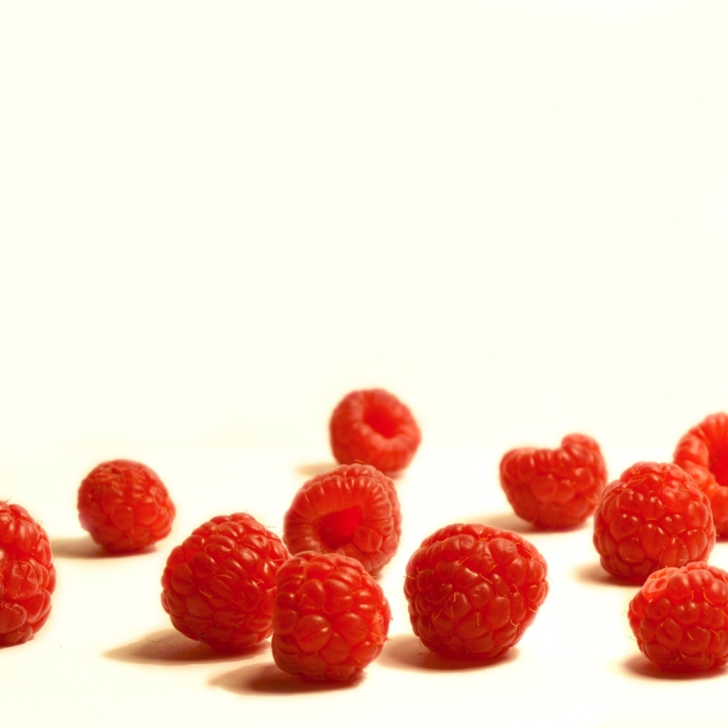 Красные ягоды малины на белом фоне крупным планом