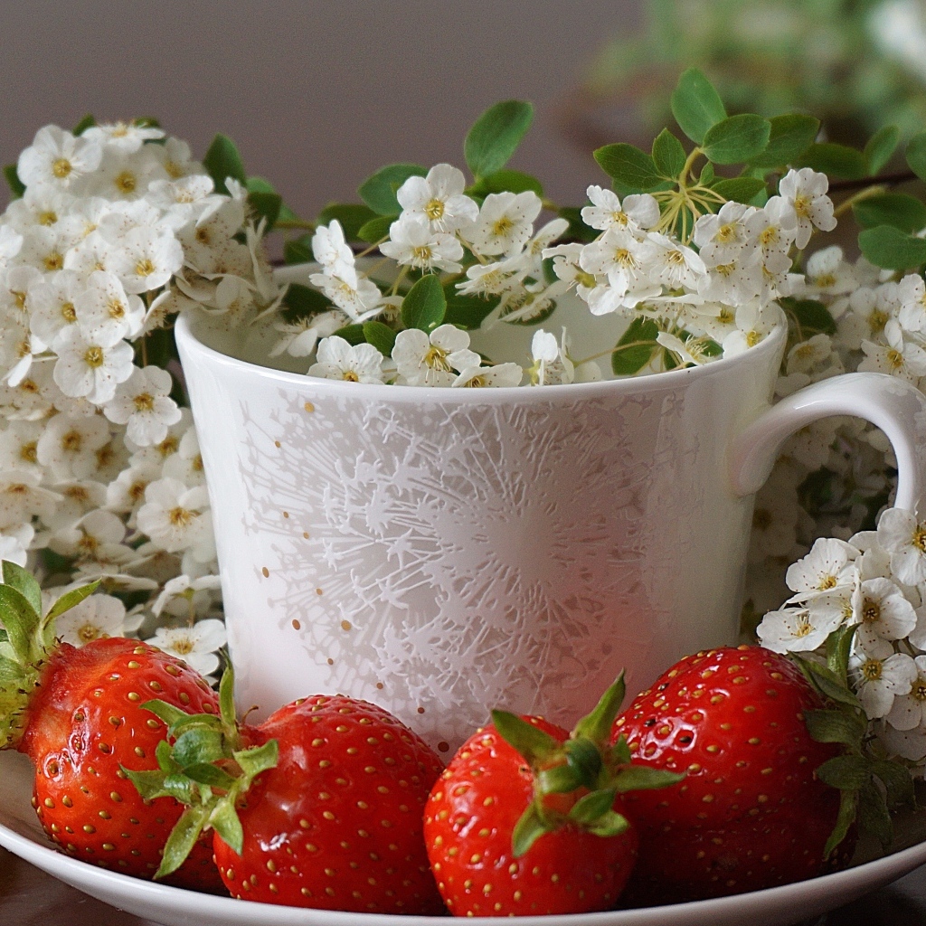 Клубника на тарелке с чашкой и белыми цветами