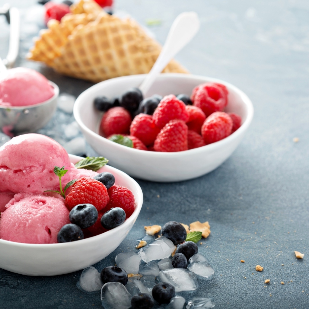 Сладкие ягоды с шариками мороженого на столе