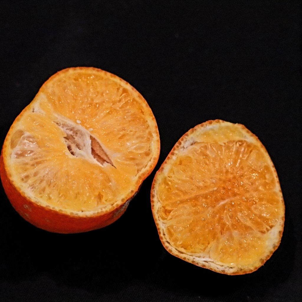 Мандарин на черном фоне крупным планом