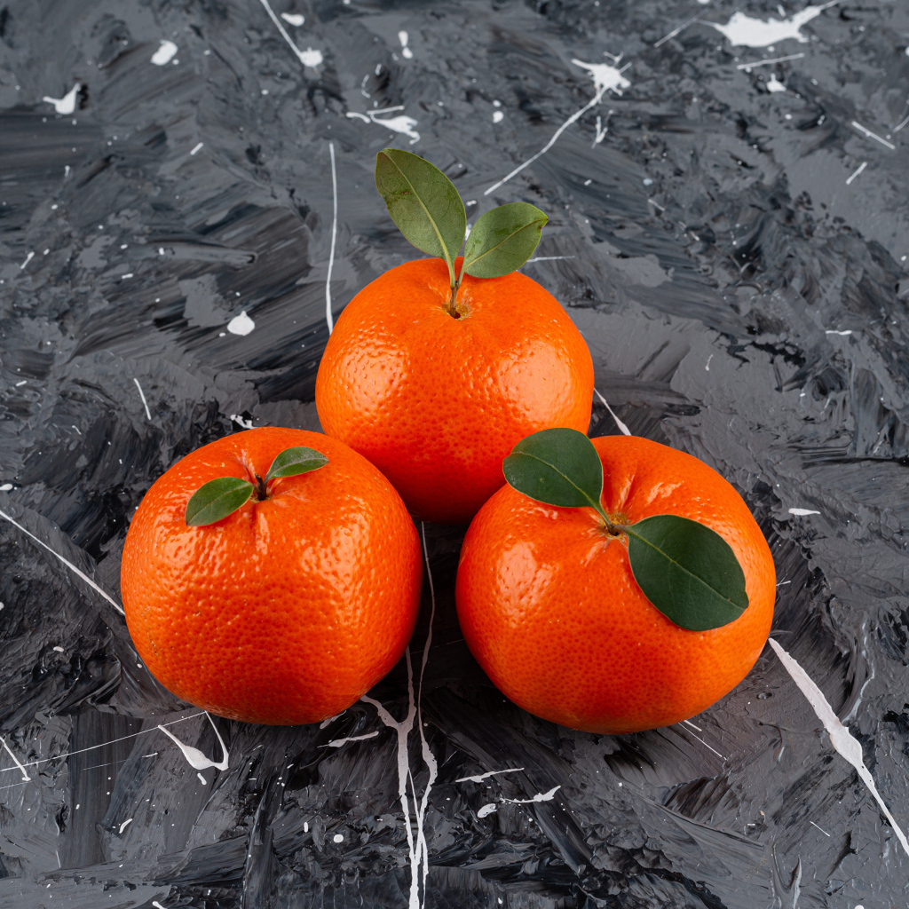 Три мандарина на сером столе