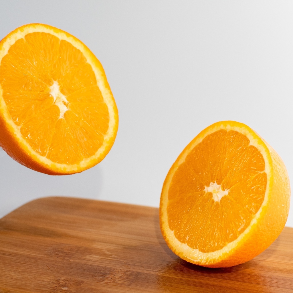Две половинки апельсина на деревянной доске