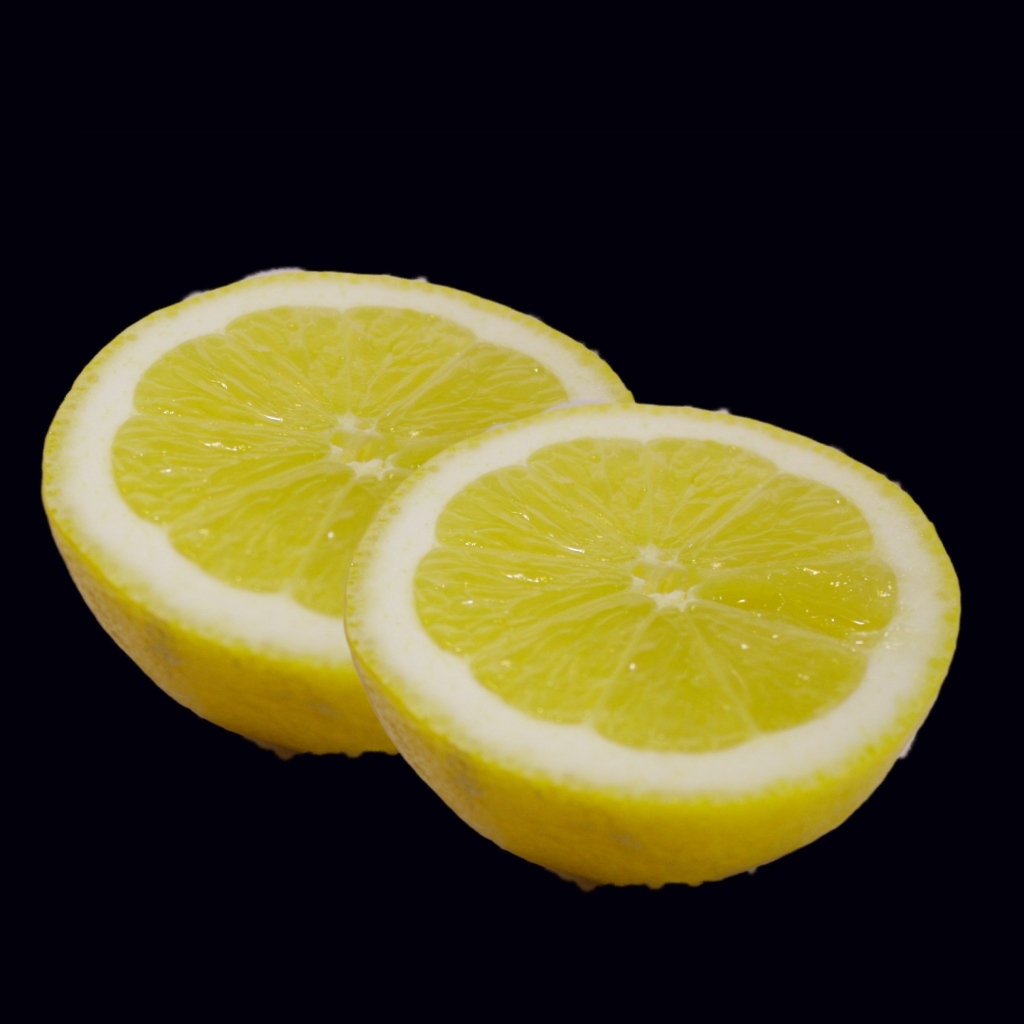 Две половинки лимона на черном фоне