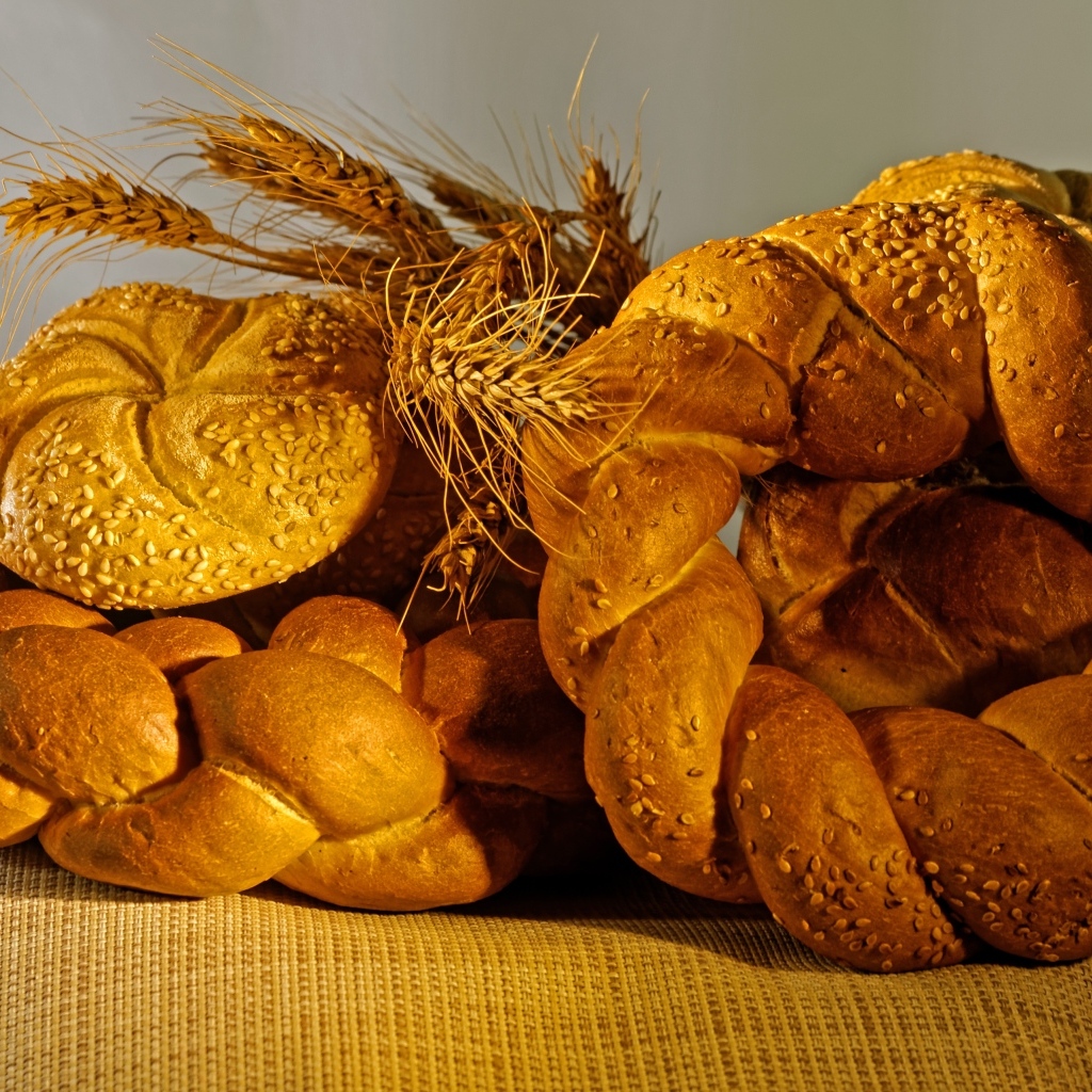 Колоски свежего хлеба на столе с пшеницей