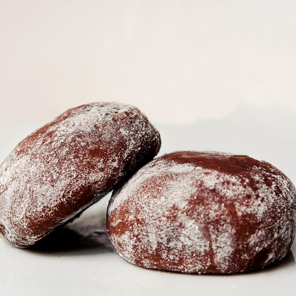 Две буханки ржаного хлеба на сером фоне