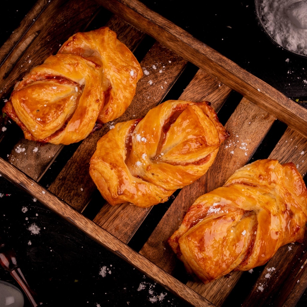 Аппетитные сладкие булочки на столе с сахарной пудрой