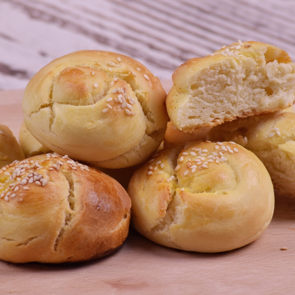 Аппетитные сладкие булочки с кунжутом на столе