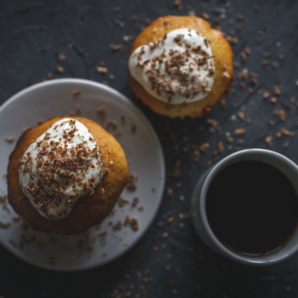 Пирожное в тертым шоколадом на столе с чашкой кофе