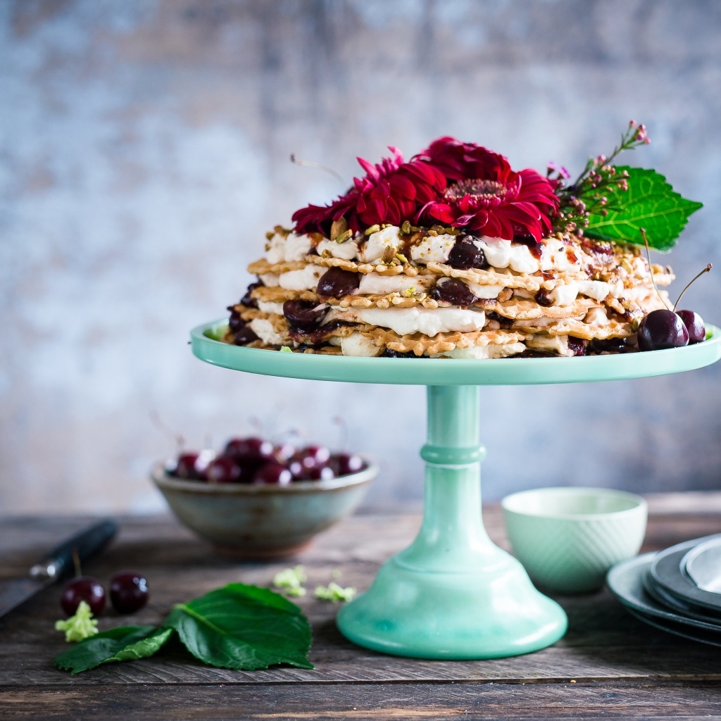 Торт с черешней и цветами герберы на столе