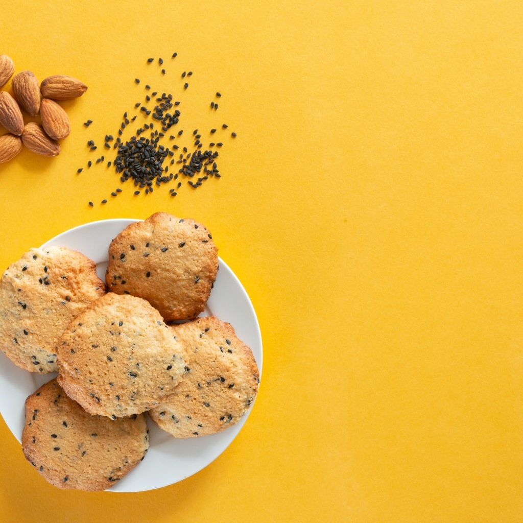 Печенье на желтом фоне с кунжутом и миндальным орехом