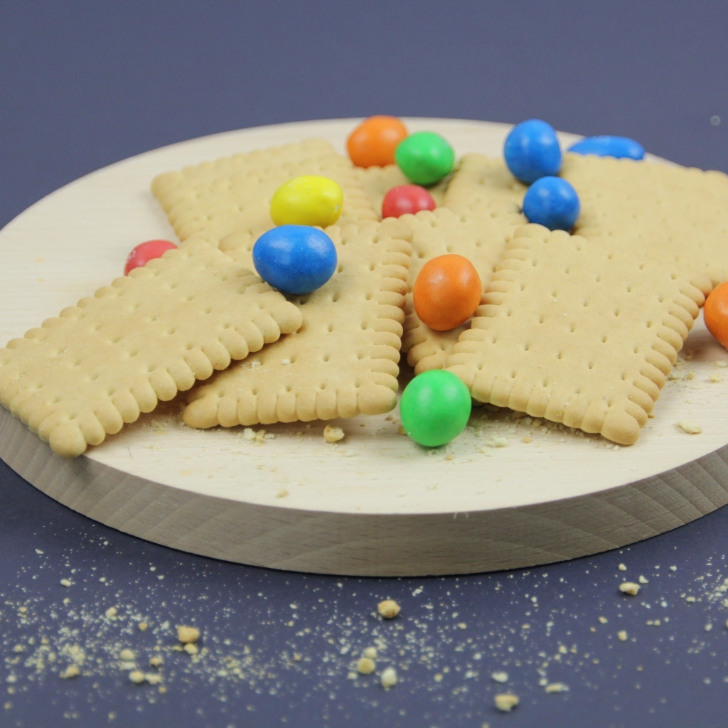 Печенье с разноцветными конфетами на сером фоне