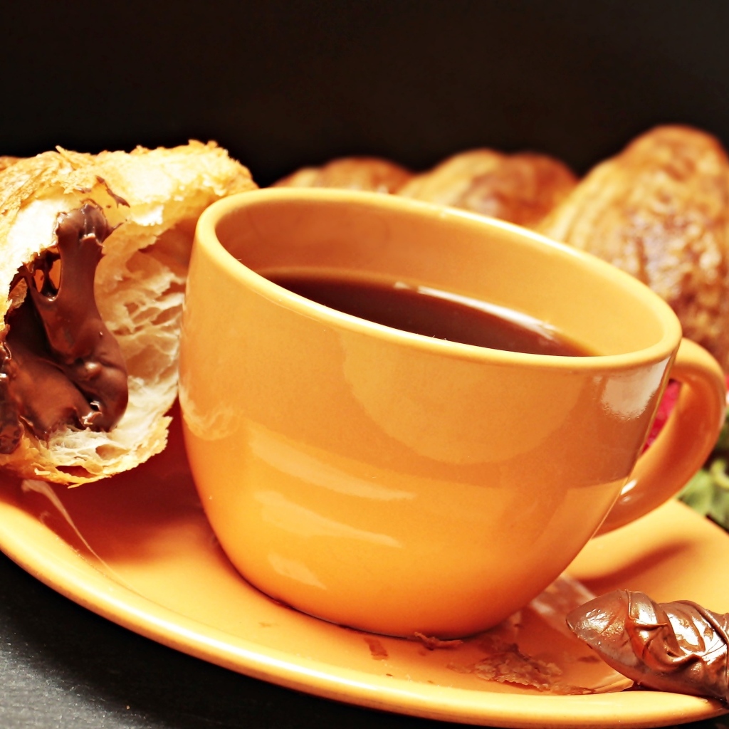 Чашка кофе на тарелке с круассанами