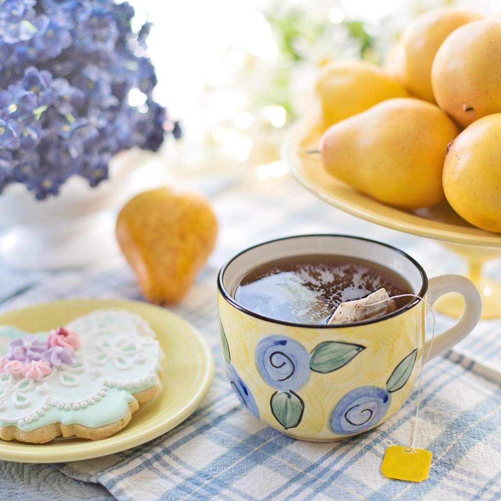 Чашка чая на столе с грушами и печеньем