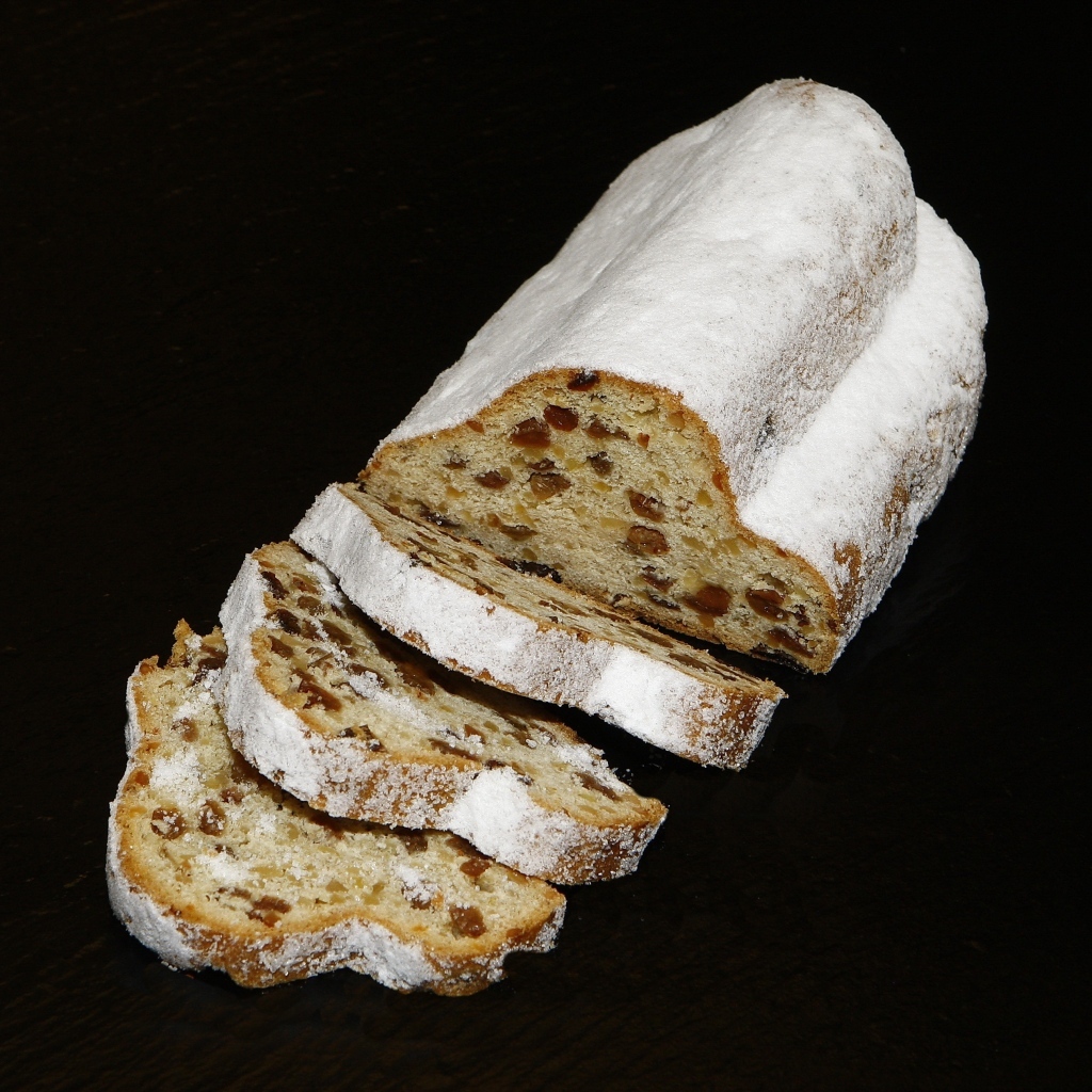 Кекс с изюмом и сахарной пудрой на черном фоне