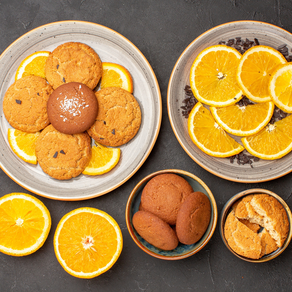 Вкусное печенье на тарелке с апельсинами