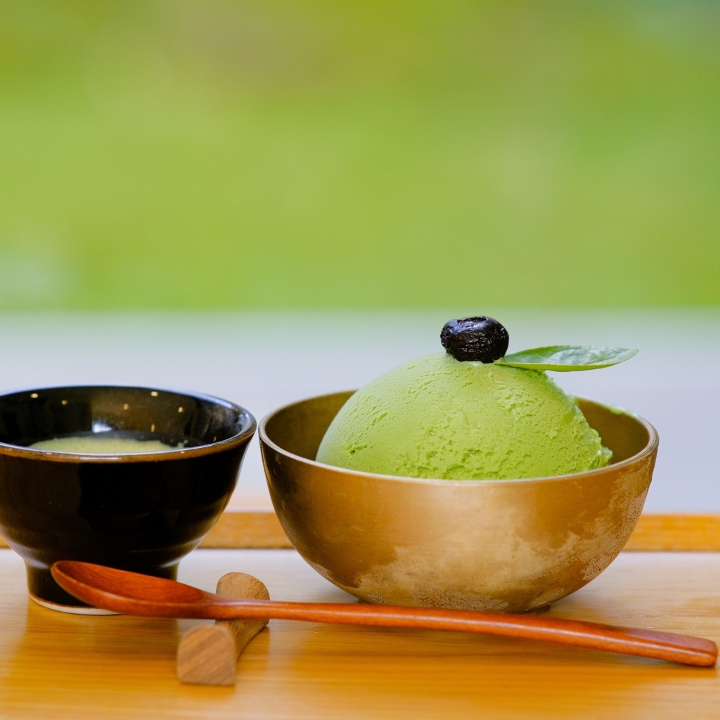 Зеленый шарик мороженого в чашке на столе