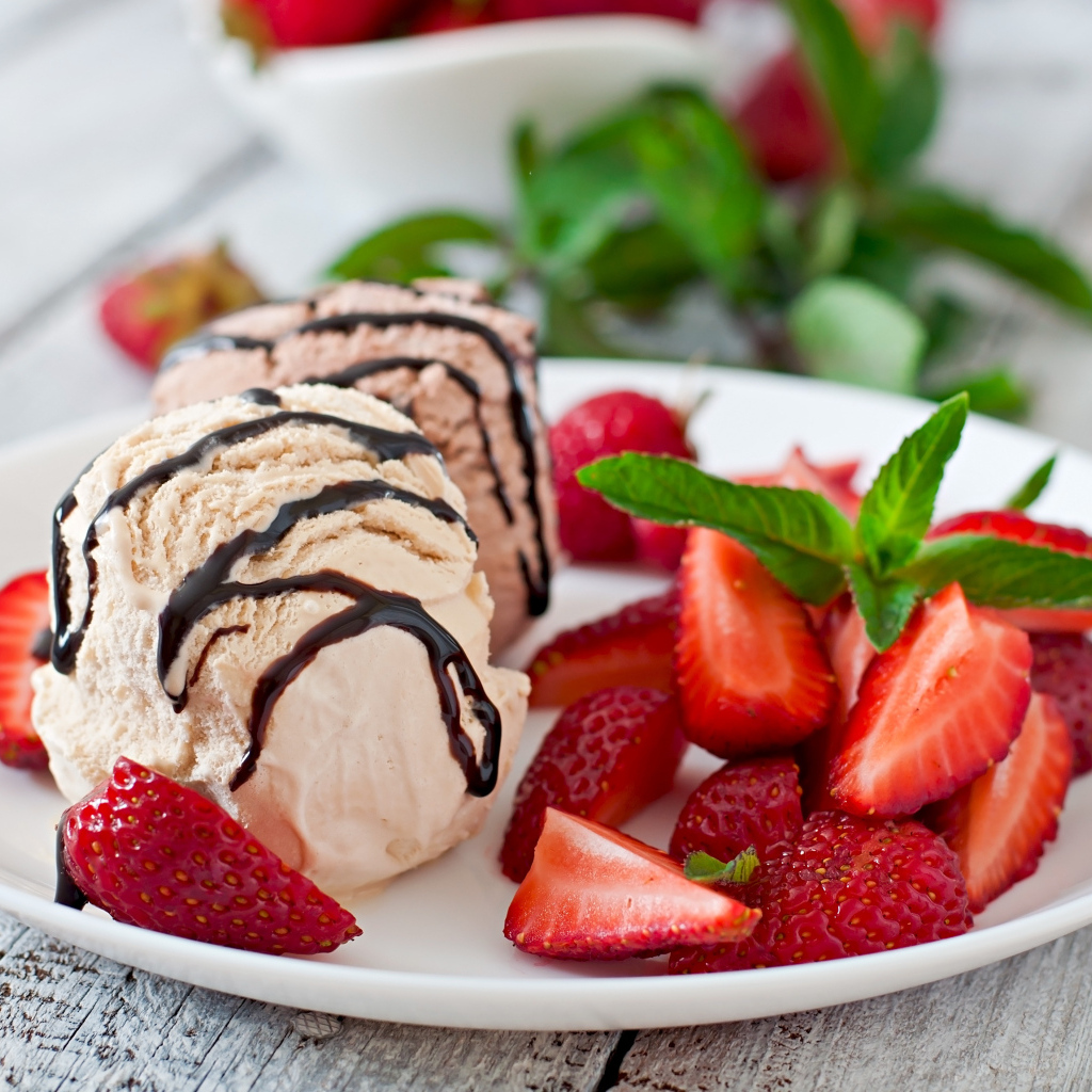 Шарики мороженого на тарелке с кусочками клубники